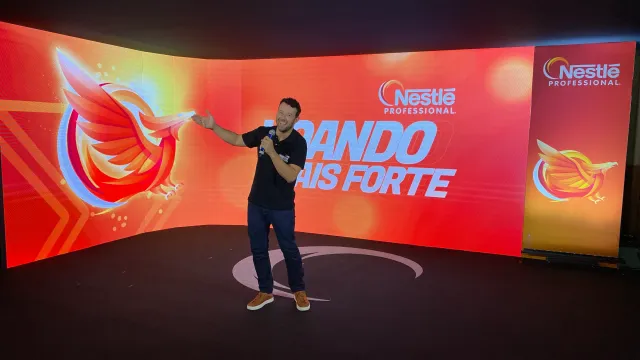Tiago Lopes apresentando evento corporativo híbrido com público no palco