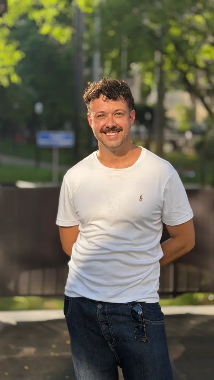 Tiago Lopes sorrindo em retrato ao ar livre